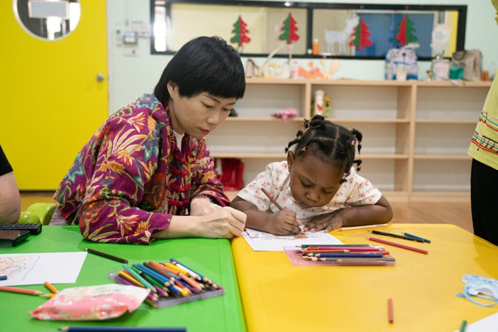 A teacher drawing with a young girl, from KidBrief’s resources for early childhood educators