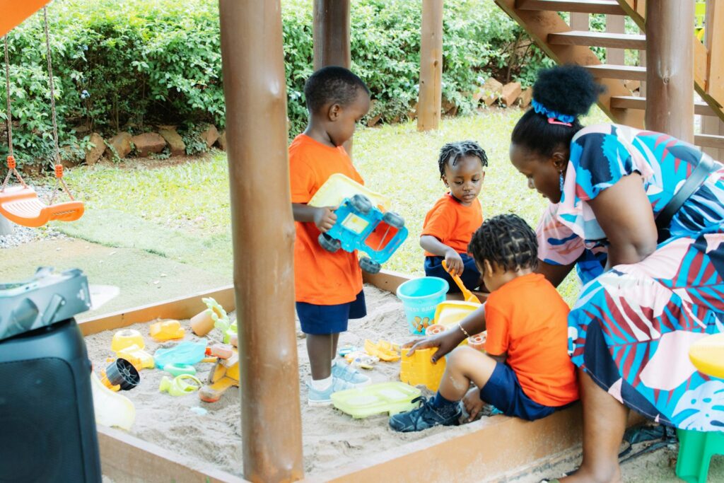 A caregiver with toddlers at play, showing how to find licensed child care in Massachusetts