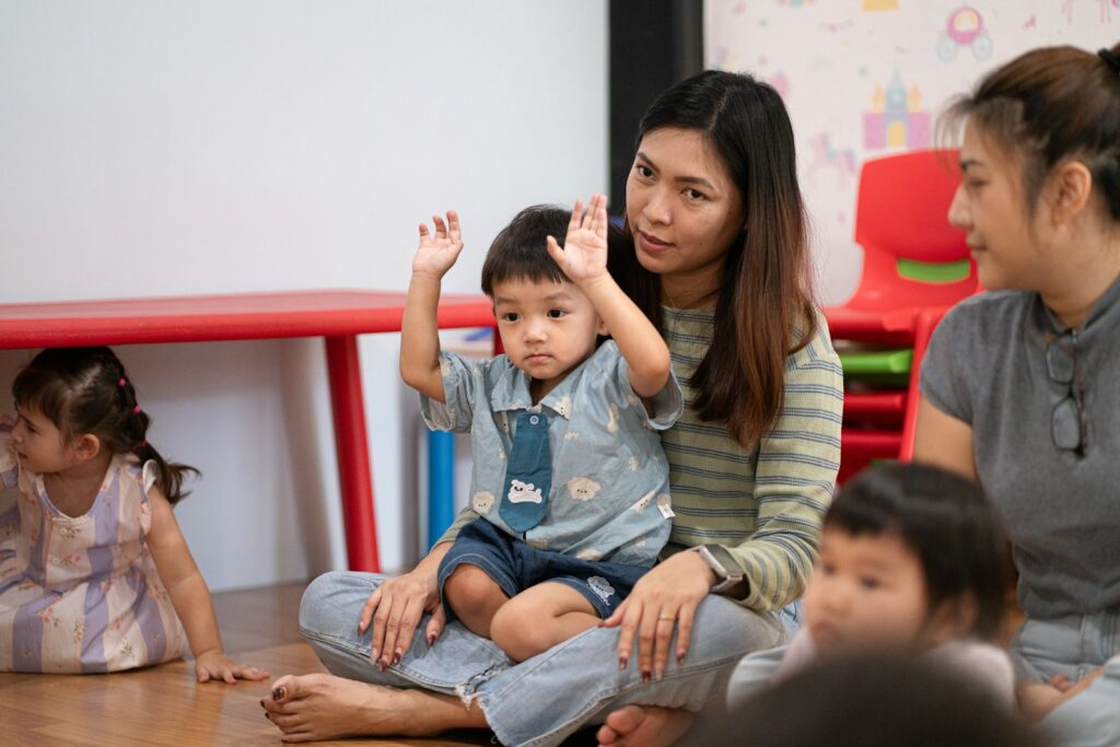 A teacher sitting with toddlers in a classroom, illustrating KidBrief’s child care director resources