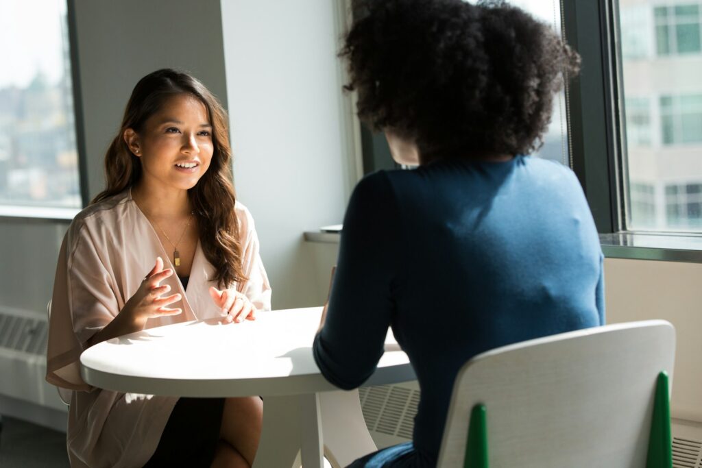 Two adults talking at a table, the kind of conversation Ask KidBrief is for